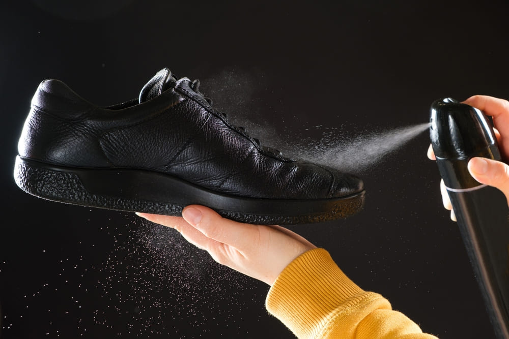persoana da cu spray pe pantofi